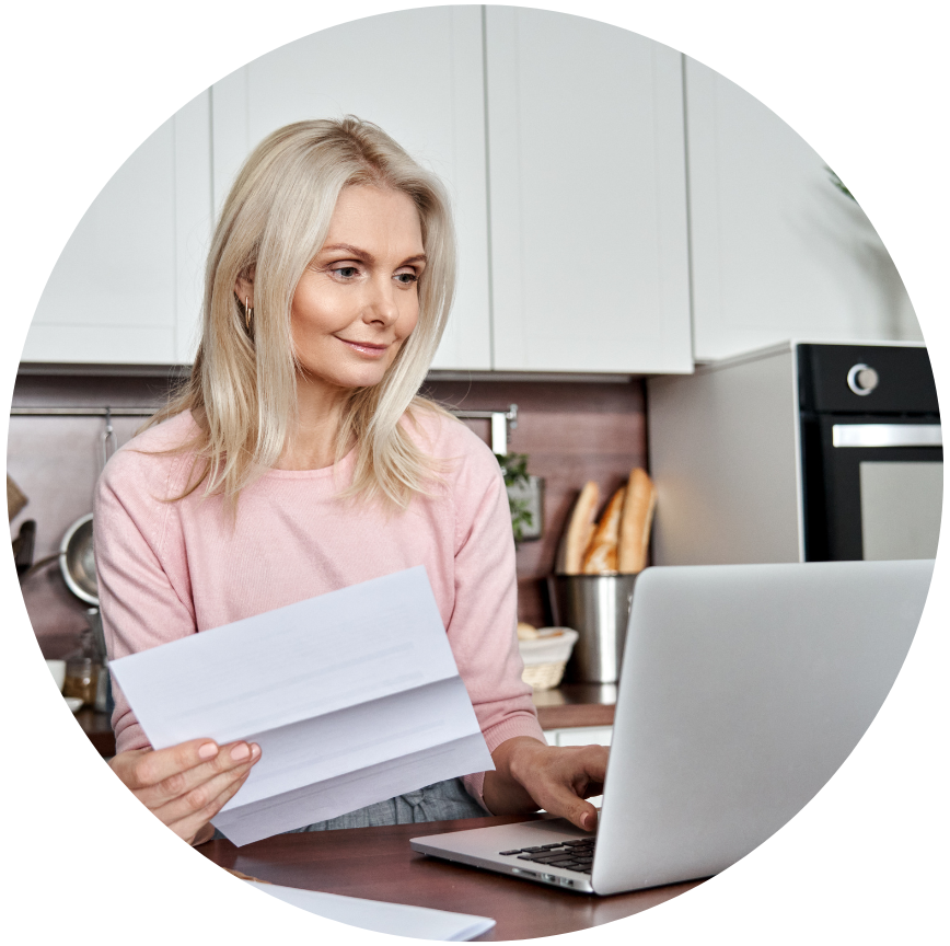 Woman holding a paper statement and using her laptop to manage her HELOC.